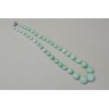 A GLASS IMITATION JADE BEAD NECKLACE Graduating green glass beads with silver bolt fastening. Weight