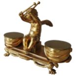 AN EARLY 20TH CENTURY GILT BRONZE INK STAND, depicting a central winged cherub flanked by draped