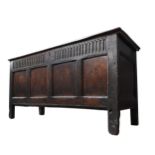 AN EARLY 17TH CENTURY OAK AND WALNUT CARVED CHEST