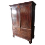 A GEORGE III MAHOGANY LINEN PRESS, the two-door cupboard housing four linen drawers, the chest