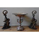A SILVER PLATED EPERGNE AND TWO CONTEMPORARY CAST-IRON DOOR STOPS, the epergne with two ornate