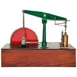 A SIMPLE ENGINEERED BEAM PUMPING ENGINE with solid flywheel, mounted on a wooden box base. 34 cms