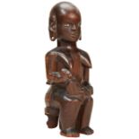 A KAMBA MATERNITY FIGURE FROM KENYA depicting a seated woman suckling a baby with a another child on