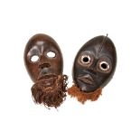 A DAN MASK FROM THE IVORY COAST with aluminium eye roundels and grass beard, another similar with