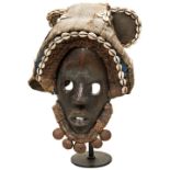A DAN MASK FROM THE IVORY COAST with canvas, hide and cowrie headdress and a plaited beard with