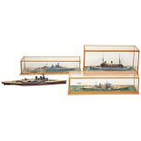 A CASED MODEL KIT OF A WWI CRUISER a cased WWI battleship model, another and an uncased model.