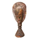 A WEST AFRICAN CARVED WOODEN HELM with a paddle shaped crest, a mask on one side and a crocodile