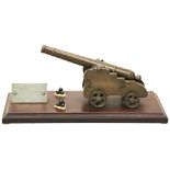 A BRASS MODEL OF AN 18TH CENTURY SHIP'S CANNON mounted on a Bakelite base with two stands of