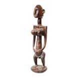 A BAMBARA MATERNITY FIGURE with incised decoration and glass bead belt. 20th century. 55 cms max