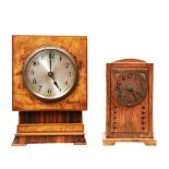 A WALNUT CLOCK, C1930 ON A STEPPED BASE and a small Continental Arts & Crafts oak mantel clock