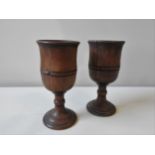 A PAIR OF LARGE 17TH CENTURY FRUIT WOOD GOBLETS, with turned stems on a spreading foot base, 24 cm