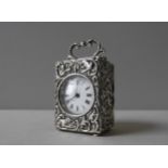 A FRENCH CARRIAGE CLOCK IN AN ORNATE SILVER REPOUSSE CASE, in a rococo style with profuse scroll