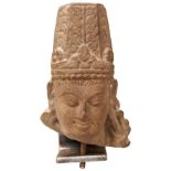 A CARVED SANDSTONE HEAD OF VISHNU, NORTHERN INDIAN, the clearly defined face with pursed lips and