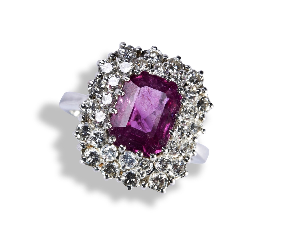 A PINK SAPPHIRE AND DIAMOND RING, the emerald-cut sapphire within a double border of brilliant-cut