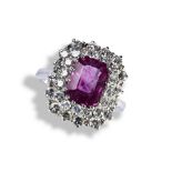 A PINK SAPPHIRE AND DIAMOND RING, the emerald-cut sapphire within a double border of brilliant-cut