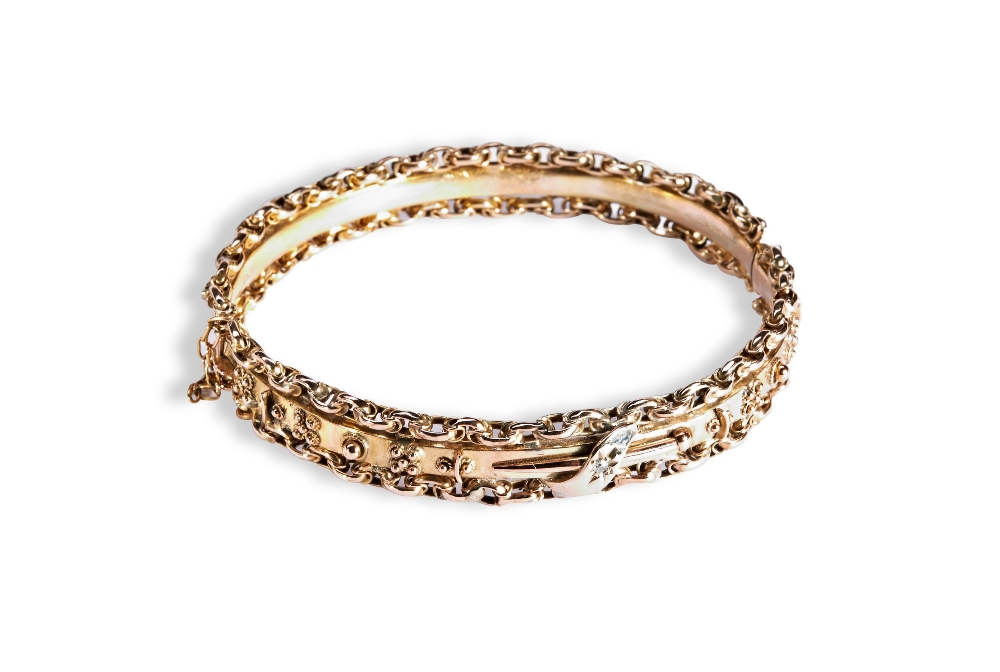 A VICTORIAN GOLD BANGLE, CIRCA 1890 with chain link decoration either side of a plain polished