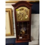 A.M.S Mahogany wall clock with brass face, with pendulum and key