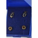 Two pairs of 9ct gold ear studs, one set with topaz, the other designed as a tri-colour gold knot, g