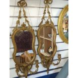 Pair of ornate hour glass shaped gilt framed mirrors with candle sconces and fine pediment detail