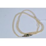 Pearl necklace with white metal, diamond and emerald clasp, metal tests positive for 9ct gold, circu