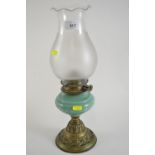 Art Nouveau lamp with green glass reservoir and brass base.