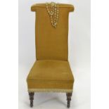 An early C20 prie dieu chair, raised on castors. Includes rosary beads