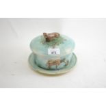 English majolica blue ground butter dish, with a cow finial to cover, the dish moulded in relief wit