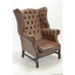 Brown leather fireside armchair, with button back and rolled arms
