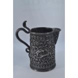 Indian white metal small jug, maker Oomersee Mawjee & Sons, Bhuj, embossed with hunting scenes of bo