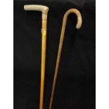 Two walking sticks, one bamboo with silver tip and one with silver collar and antler handle