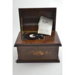 A 20th century Swiss Romance music box in domed walnut case inlaid with musical instruments and flow