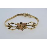 Yellow metal tri-colour bracelet, with an open work floral design to the front, tested positive for