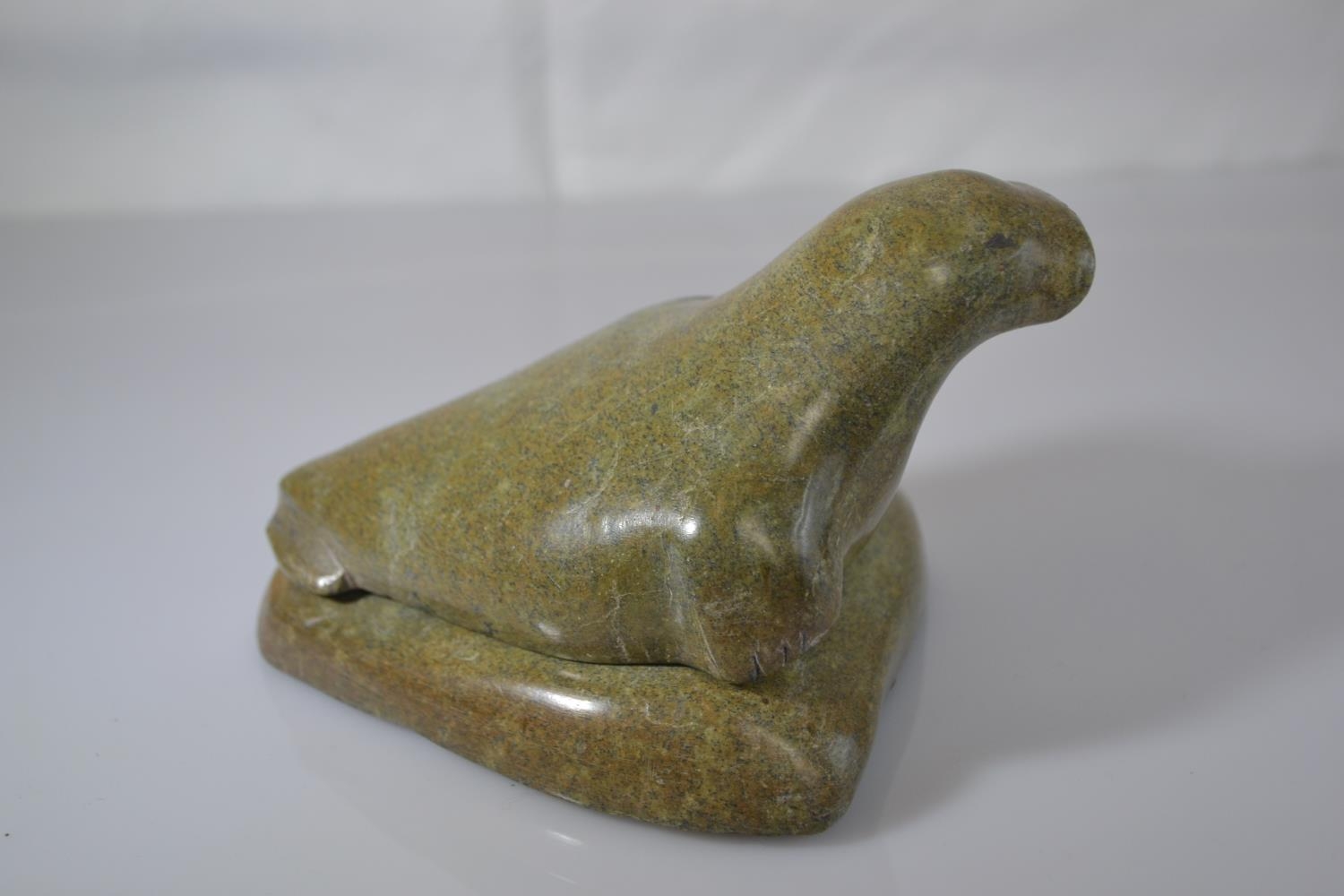 Canadian Eskimo Art green stone Inuit carving of a walrus on a rock, length 13.5cm x height 8.5cm 