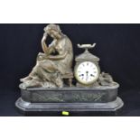 Slate mantle clock with a figure of a seated lady, with key. width 48 cms, ht 39 cms, clock face dia