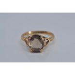 9ct gold ring claw-set with a smoky coloured stone, 9x8mm, size O/P, gross weight 2.2 grams