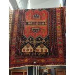 Handmade wool rug. Red ground with geometric designs 255cm x 150cm