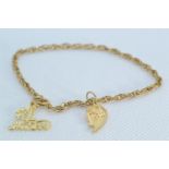 14ct gold bracelet with a 14ct gold '#1 Mom' & a yellow metal half heart charm, the yellow metal cha