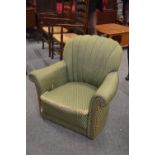 Edwardian shell backed arm chair on castors with green upholstery.