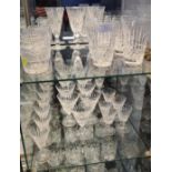 Waterford crystal glasses over two shelves, including; six tumblers and other matching assorted liqu