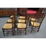 Eight Victorian oak rush seated chairs including two carvers. Includes cushions.