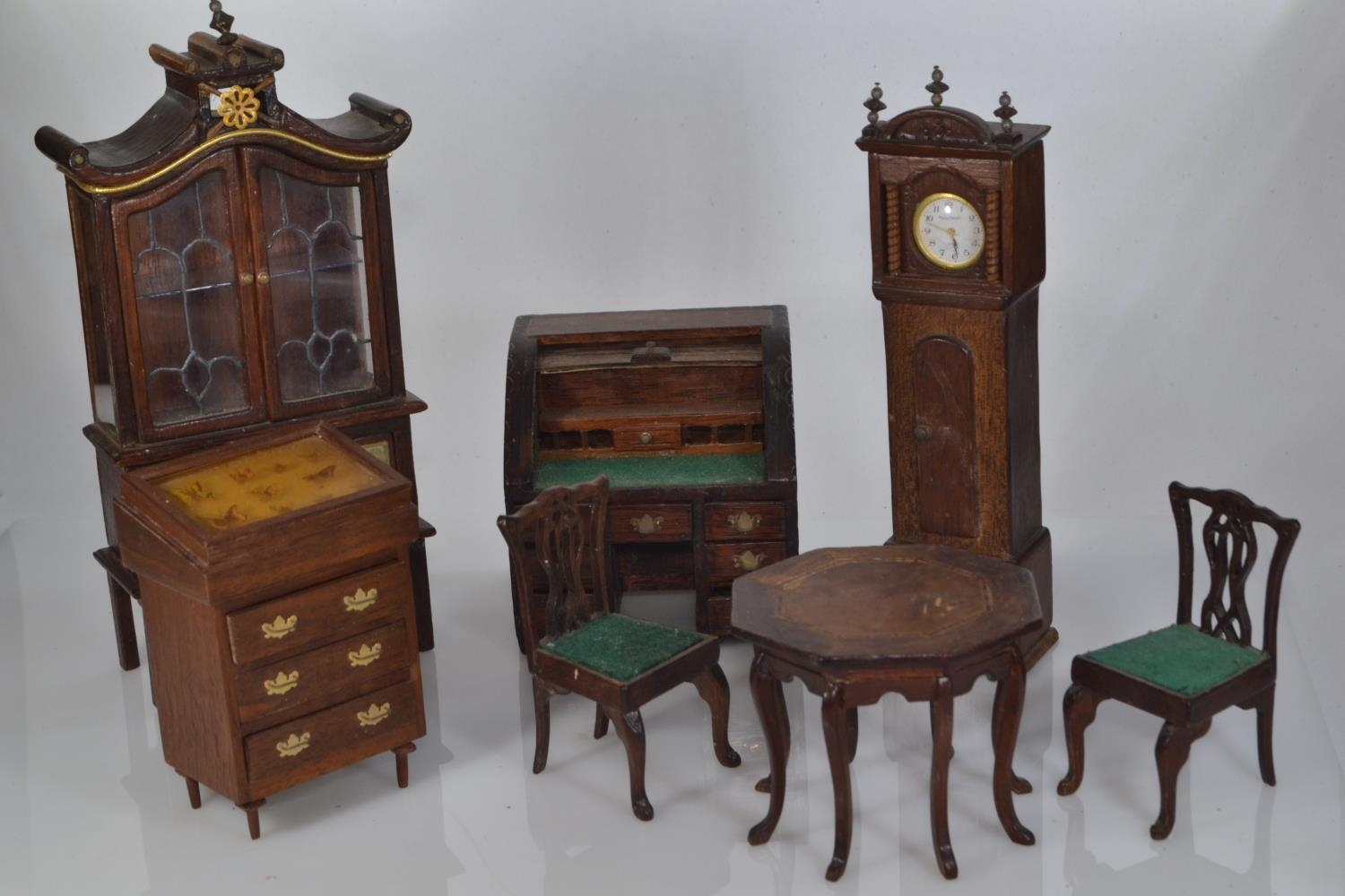 Collection of wooden dolls house furniture including a tambour knee hole desk, a grandfather's clock