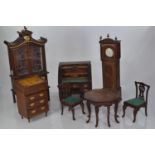 Collection of wooden dolls house furniture including a tambour knee hole desk, a grandfather's clock