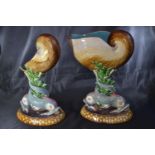 Minton majolica nautilus shell centrepiece, supported by two dolphins midst seaweed on an oval base,