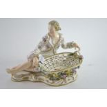 John Bevington porcelain figural sweetmeat dish, modelled as a seated gentleman & floral encrusted b