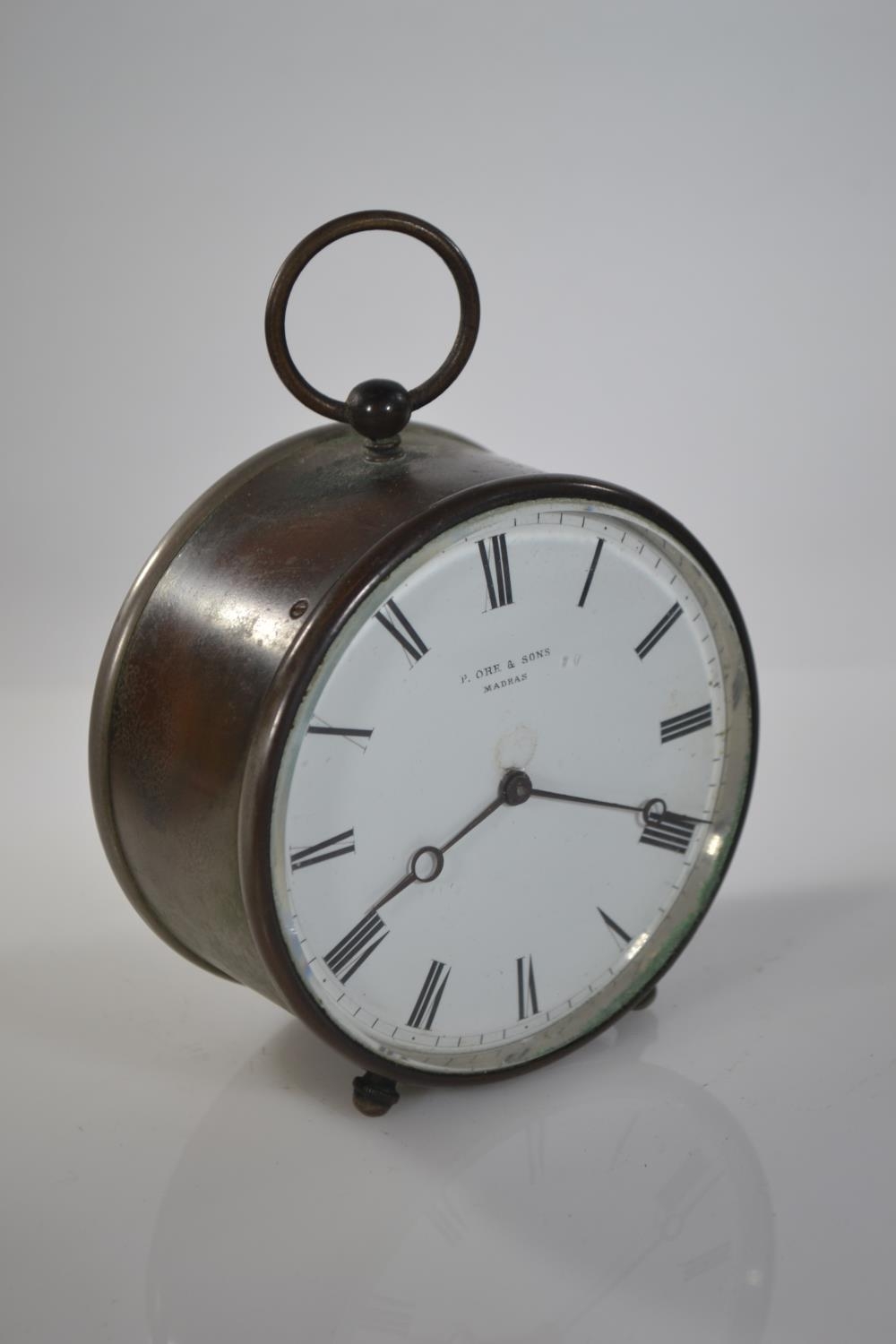 French V.A.P Brevete drum clock retailed by P. Ore & sons Madras, with key, dia. 9.5cm 
