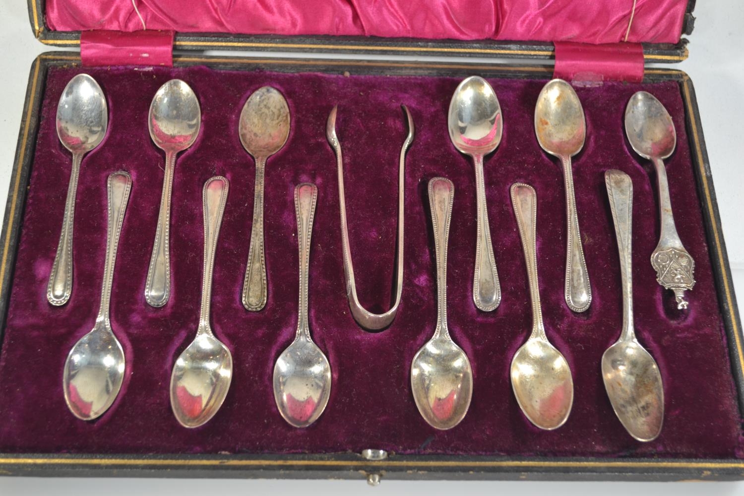 Cased matched part set of ten coffee spoons & a pair of sugar nips, makers Walker & Hall and W S Sav