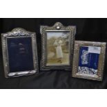 Three silver photo frames, largest marked T.S LTD with lion, the other two hallmarked for Carr's of