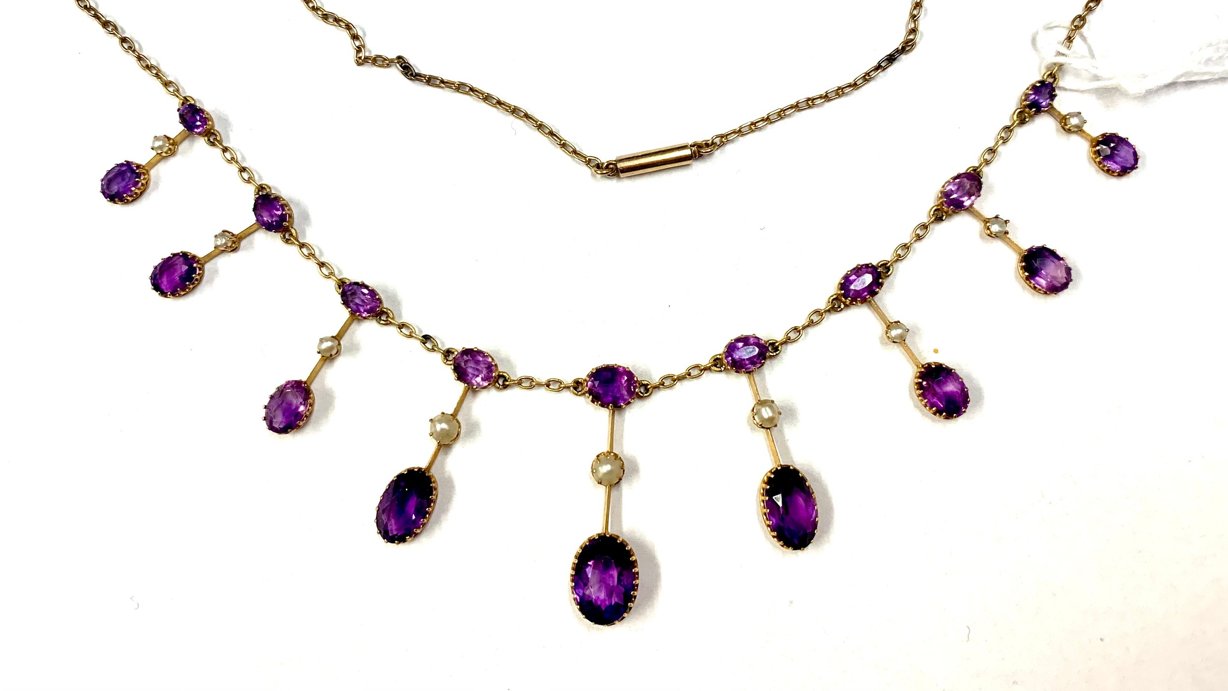 An Edwardian amethyst and half pearl gold fringe necklace, comprising graduating claw-set oval-cut a - Image 2 of 8