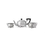 AN ARTS AND CRAFTS HAMMERED SILVER THREE PIECE TEA SERVICE, BARKER BROTHERS