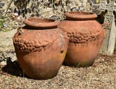 A large pair of terracotta twin handled garden urns